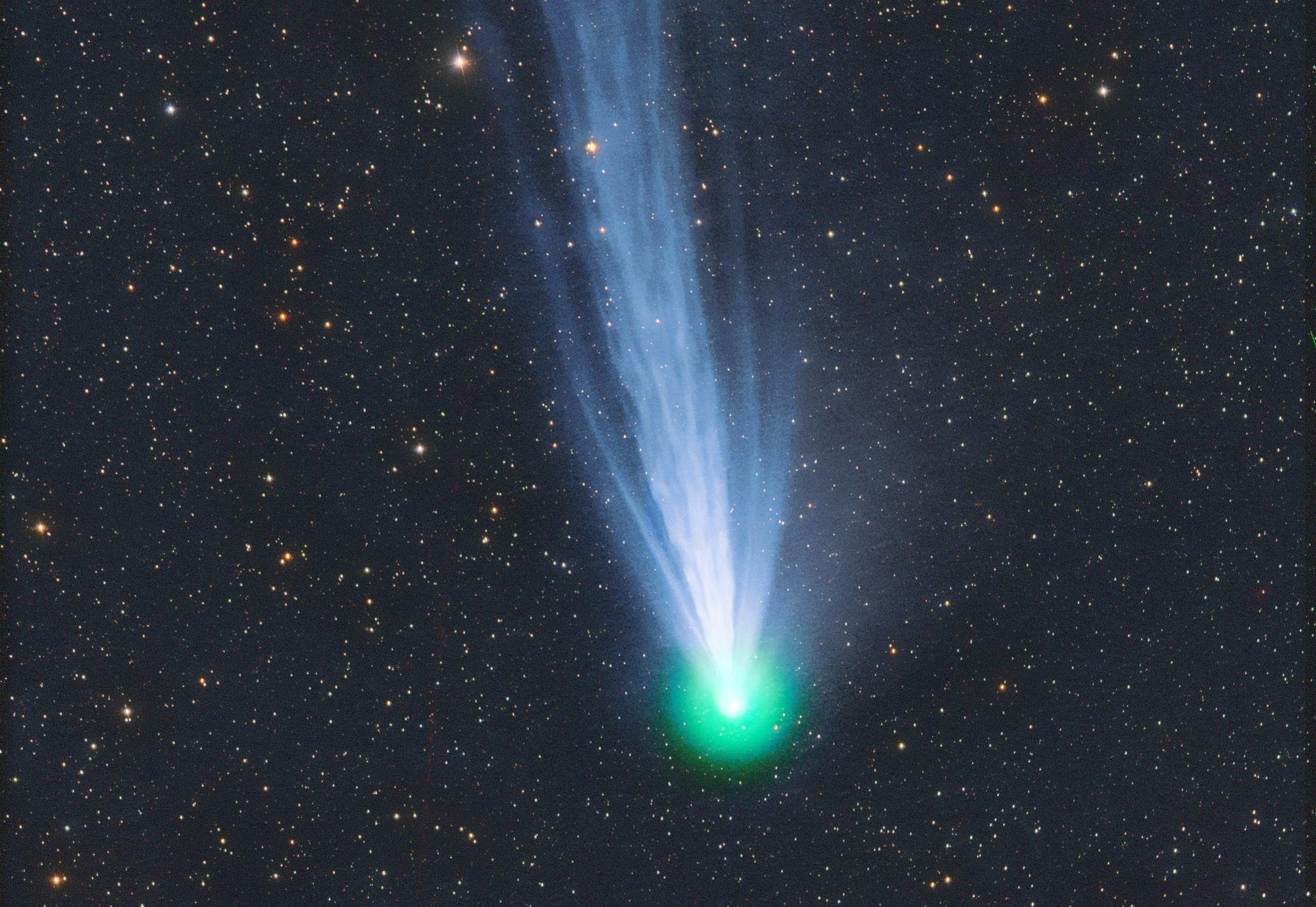 Das Foto zeigt den Komet 12P/Pons-Brooks. Er leuchtet grün vor dem Sternenhimmel und zieht einen blau-weißen Schweif nach sich.