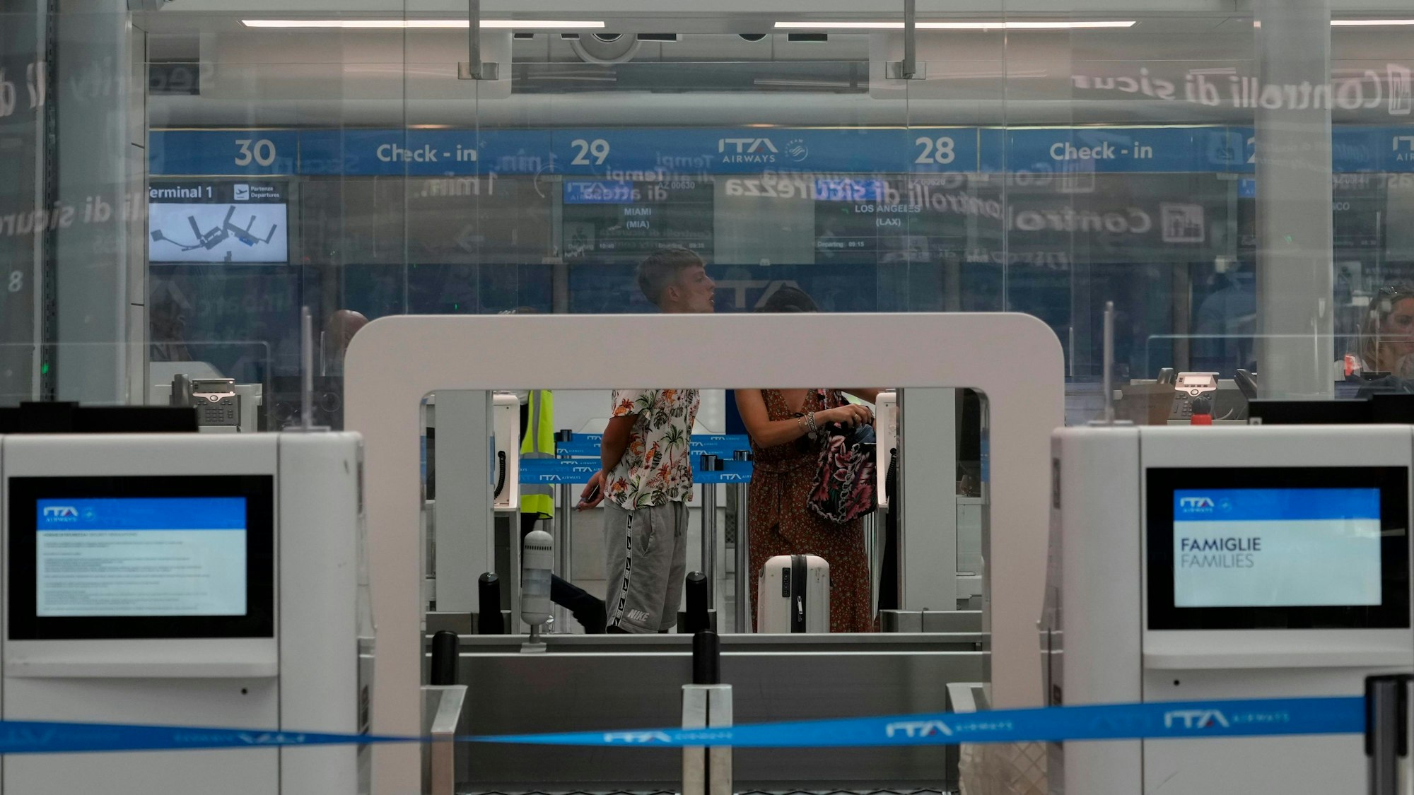 ARCHIV - 15.07.2023, Italien, Fumicino: Passagiere warten an einem Abfertigungsschalter auf dem internationalen Flughafen Rom-Fiumicino.