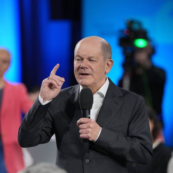 Zu sehen ist Bundeskanzler Olaf Scholz mit einem Mikrofon in der Hand.