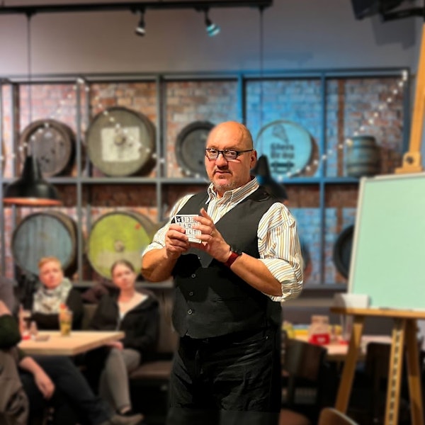 Ein Mann steht in einem Lokal mit Karten in der Hand.