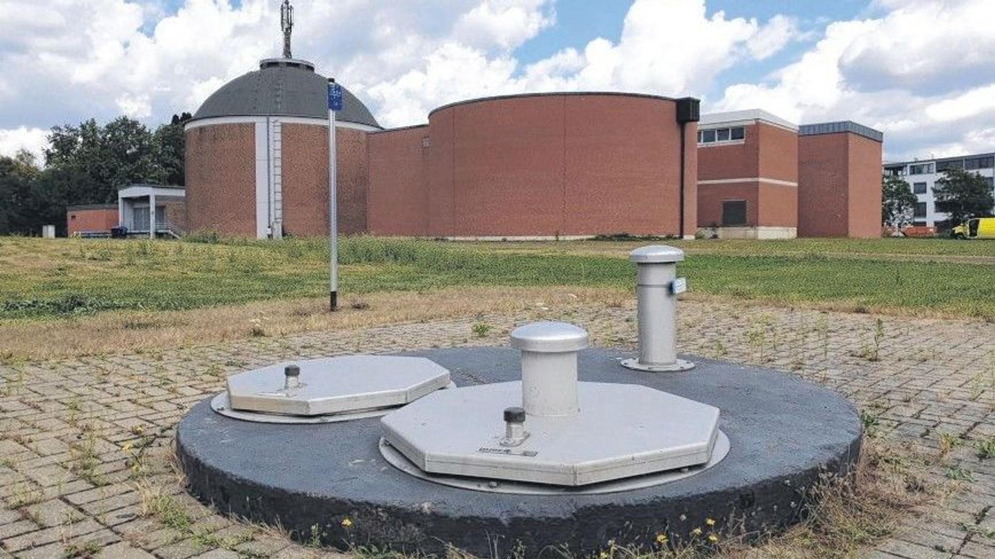 Das Foto zeigt einen abgedeckten Brunnenschacht vor den Gebäuden des Wasserwerks in Efferen.