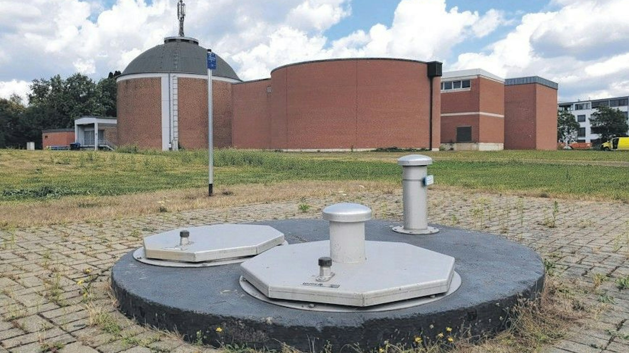 Das Foto zeigt einen abgedeckten Brunnenschacht vor den Gebäuden des Wasserwerks in Efferen.