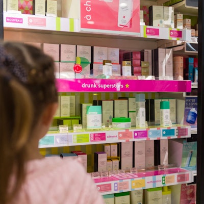 Kleines Mädchen steht vor einem Regal bei Sephora