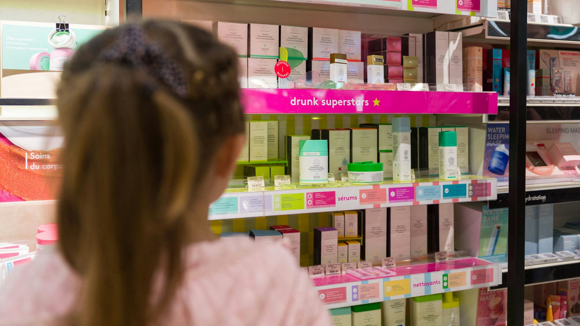 Kleines Mädchen steht vor einem Regal bei Sephora