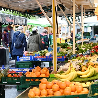 Menschen gehen an den Ständen des Wochenmarkts am Auerbachplatz in Köln-Sülz vorbei. Foto von Alexander Schwaiger