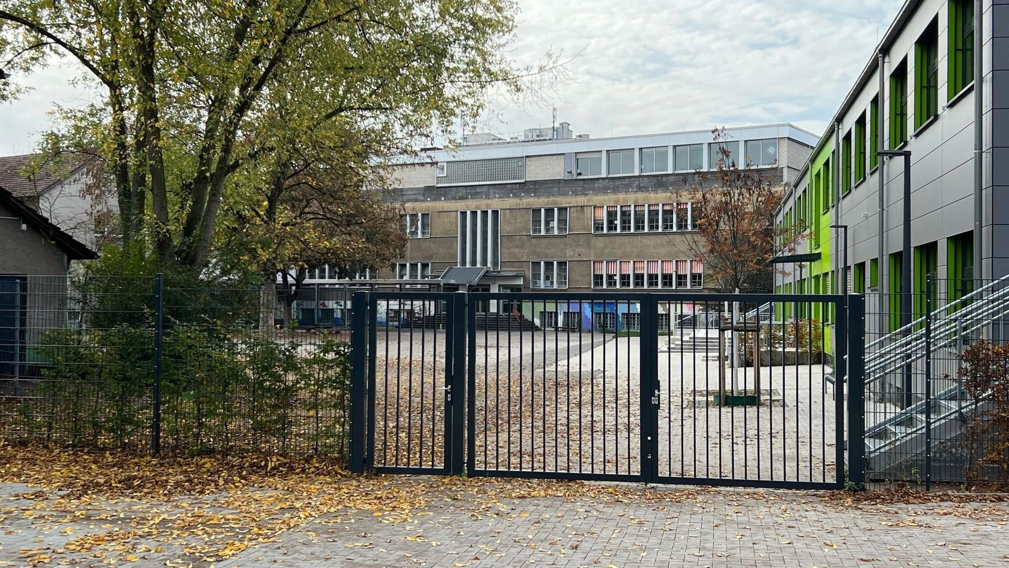 Zu sehen ist der Schulhof der Gemeinschaftsgrundschule Porz-Mitte und Schulgebäude.