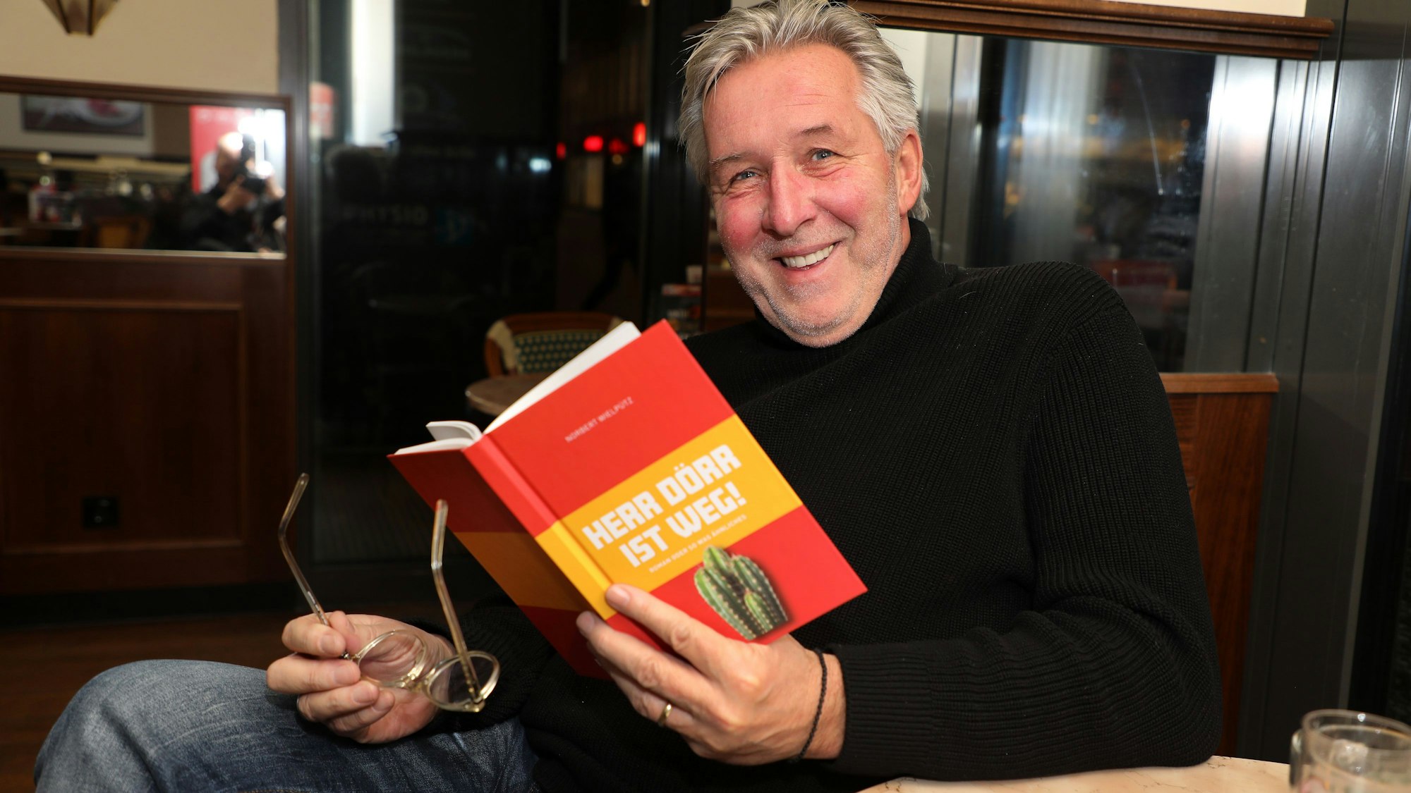 Norbert Wielpütz sitzt mit seinem Roman „Herr Dörr ist weg!“ in einem Bergisch Gladbacher Café.