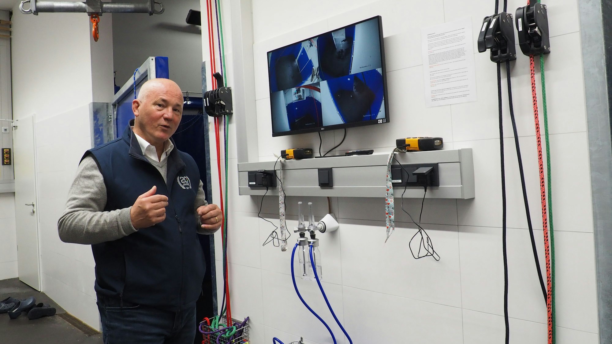 Dr. Thomas Weinberger steht vor einem Überwachungsmonitor, der die Aufwachboxen der Tierklinik zeigt.