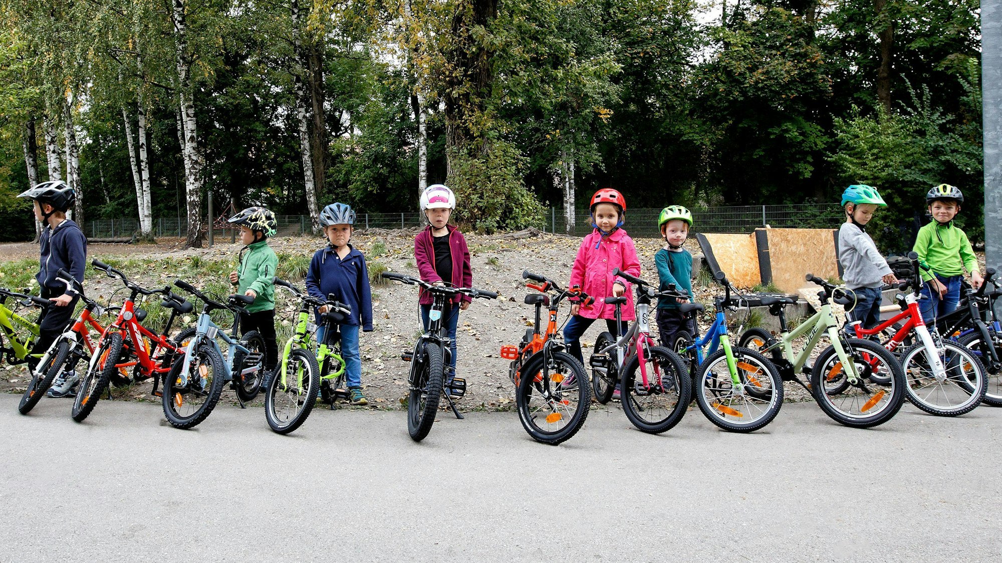 Viele Kinder stehen mit Fahrrädern in einer Reihe