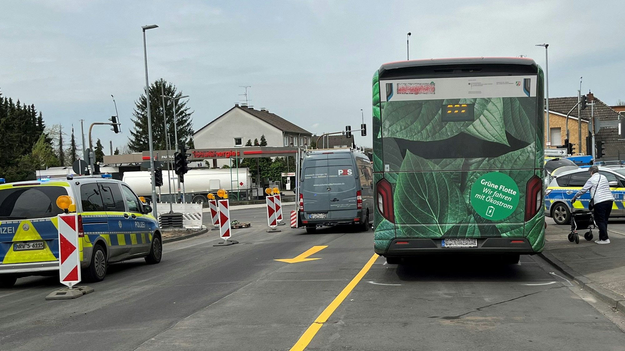 Ein Bus steht mit Unfallmarkierungen auf der Paffrather Stra0e in Bergisch Gladbach. Daneben stehen Polizeifahrzeuge.