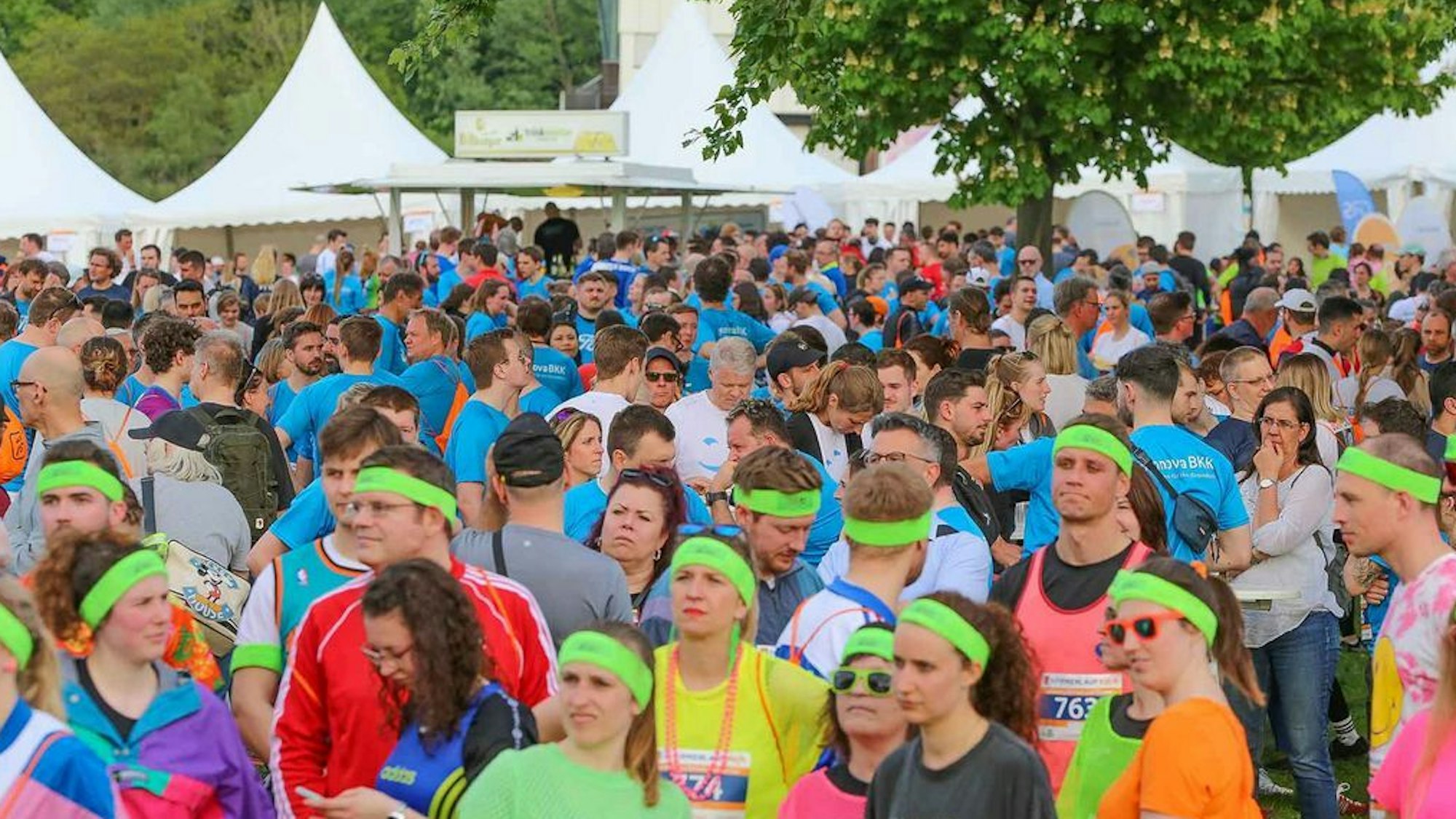 Zu sehen ist eine Menschenmenge vor Partyzelten.