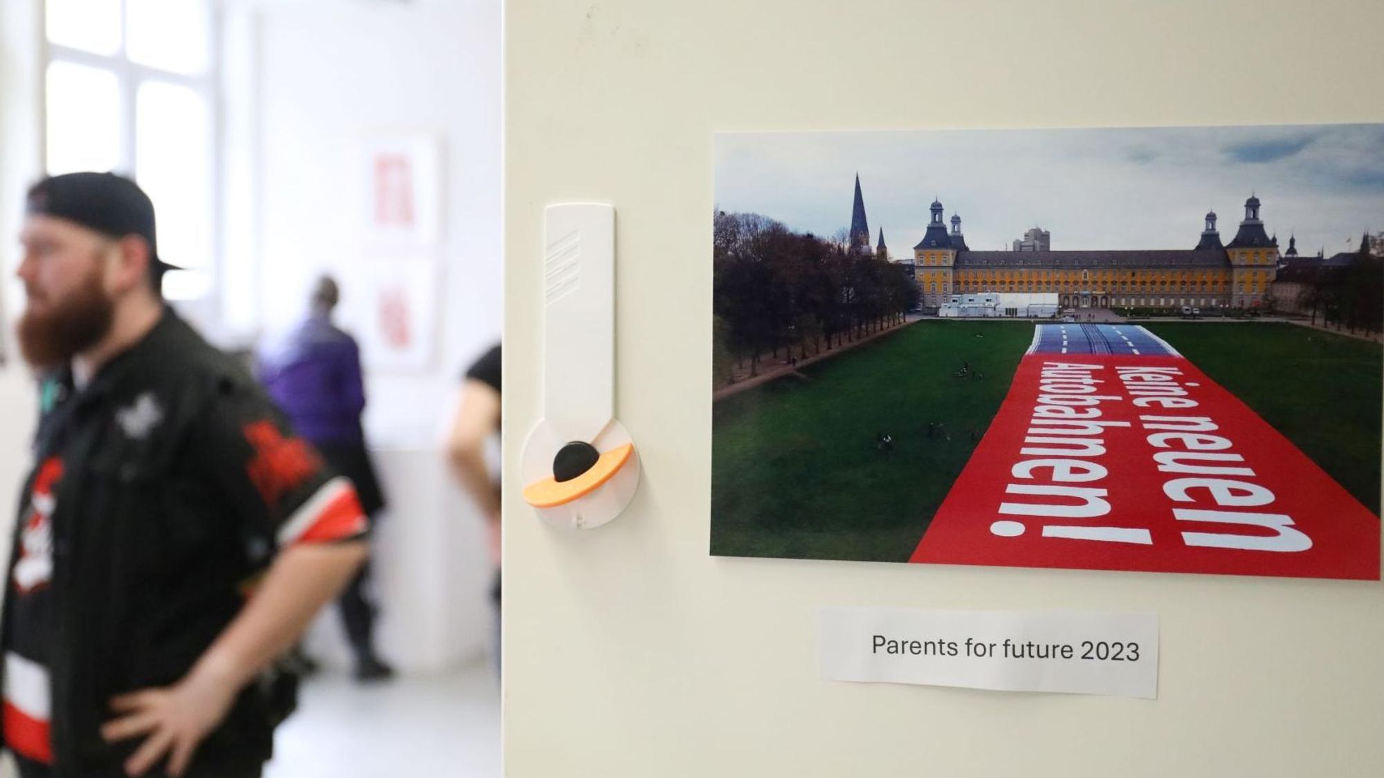 Ein Besucher in der Ausstellung neben einem Foto, das den Bonner Hofgarten und die Universität zeigt.
