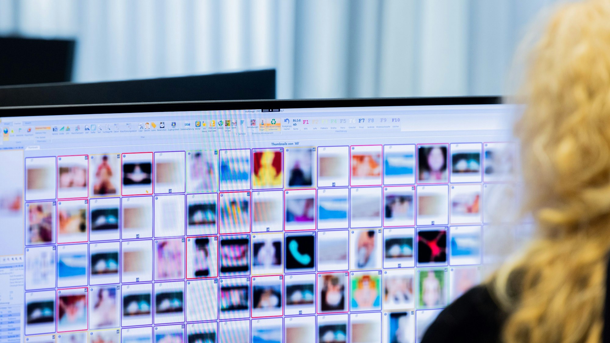 Nordrhein-Westfalen, Düsseldorf: Eine Ermittlerin sitzt vor Monitoren mit unkenntlich gemachten Fotografien, die teilweise sexuellen Missbrauch zeigen, am Hinweistelefon im Landeskriminalamt. (Archivbild)