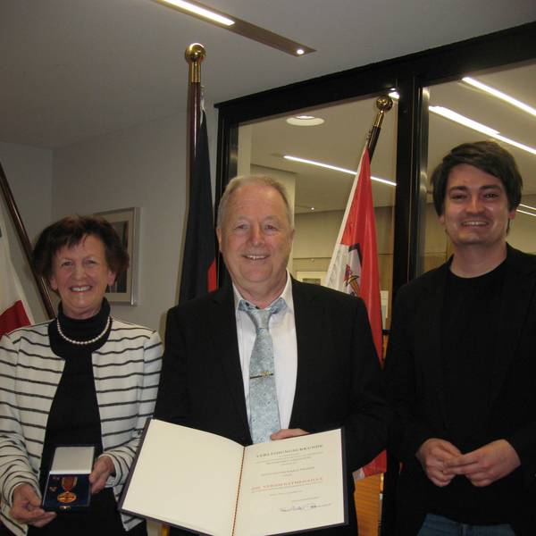 Der mit der Bundesverdienstmedaille ausgezeichnete Hennefer Heiner Krautscheid (71) steht zwischen Vizelandrätin Notburga Kunert und Bürgermeister Mario Dahm.