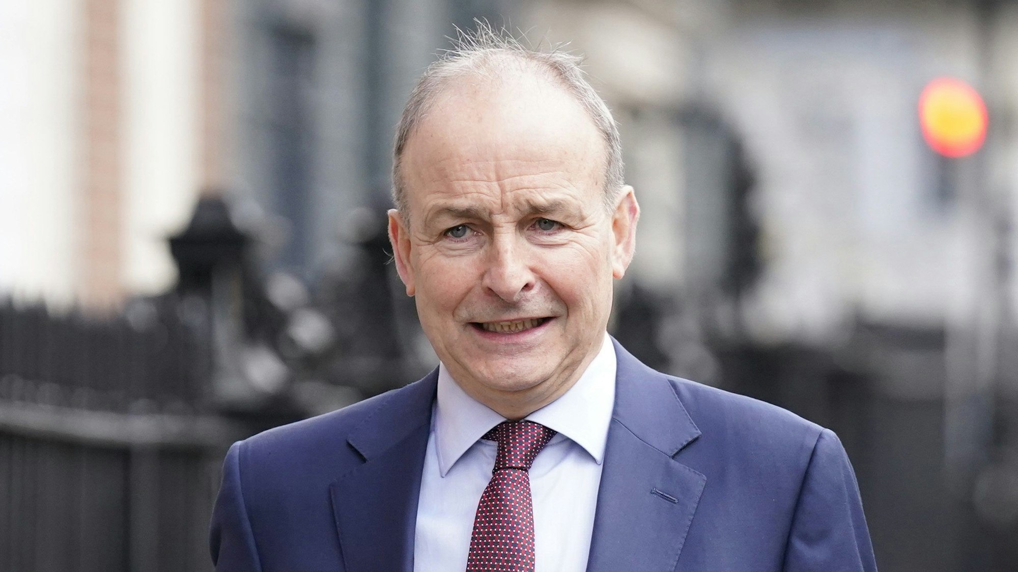 Nahaufnahme von Micheál Martin, Vorsitzender der Partei Fianna Fail, der auf einem Gehsteig unterwegs ist.