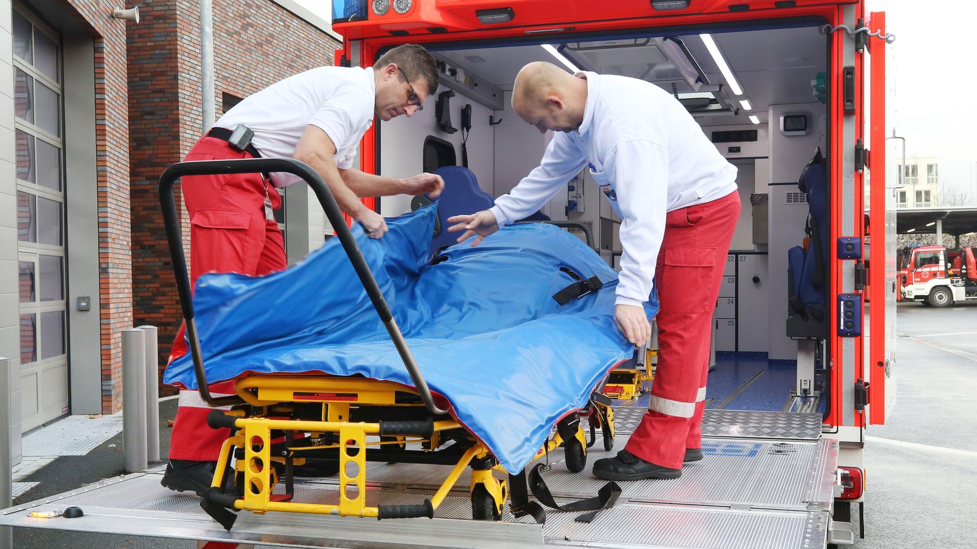 Mit einer Schwerlasttrage hantieren die Feuerwehrleute Oliver Schwarz (l) und Marc Elmhorst auf der Hebebühne des Schwerlastrettungswagens.