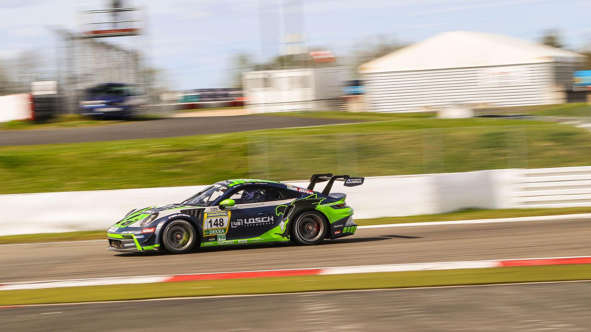 Der Porsche von Tobias Müller bewegt sich schnell auf dem Nürburgring. Der Hintergrund verschwimmt.