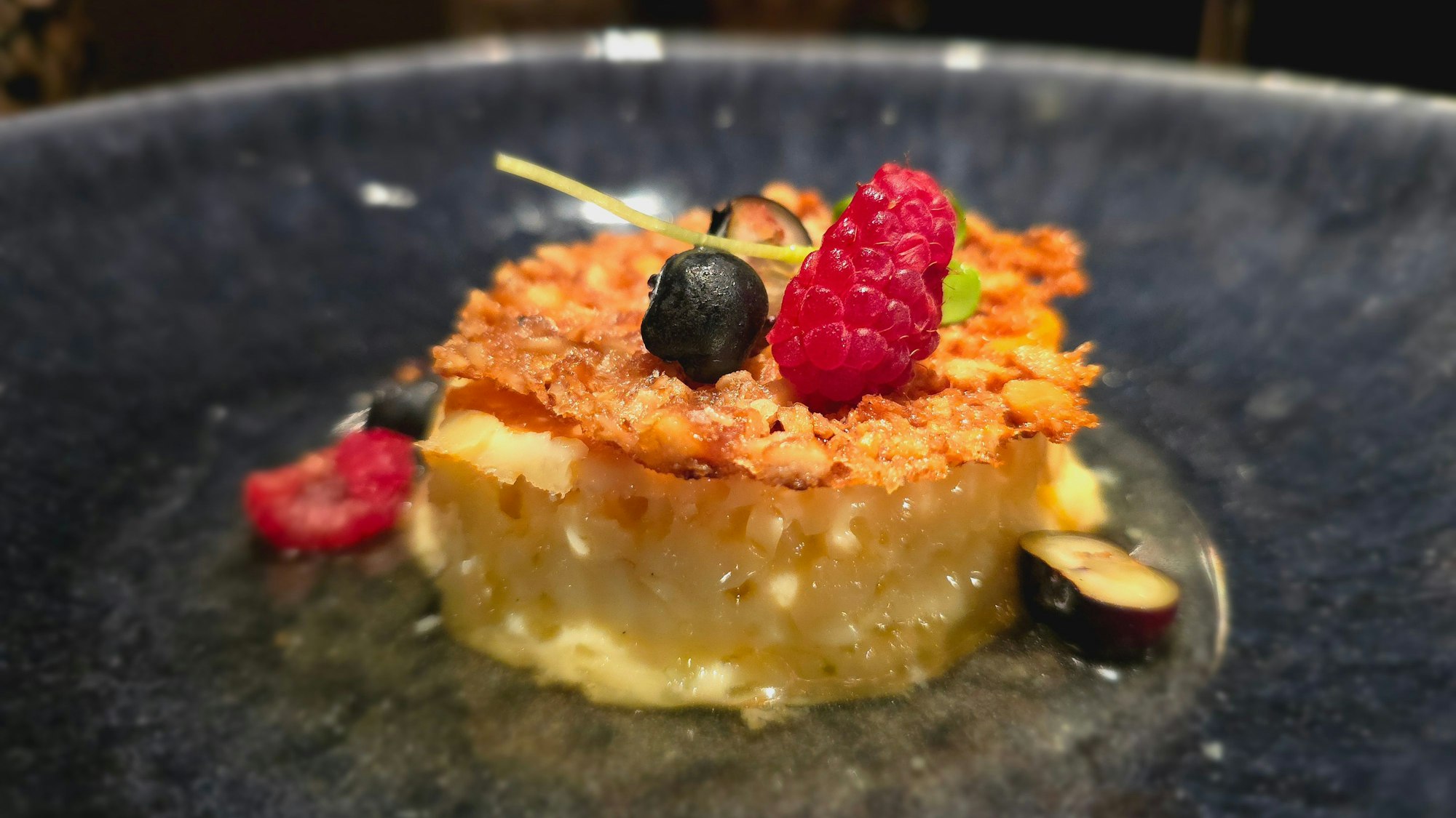 Crème Caramel mit Beeren angerichet auf einem Teller