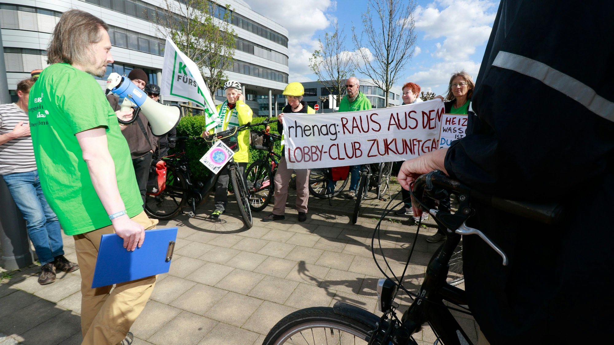 Demonstranten mit Fahrrädern stehen auf einer Straße. Auf einem Transparent steht: „Rhenag: Raus aus dem Lobby-Club Zukunft Gas“
