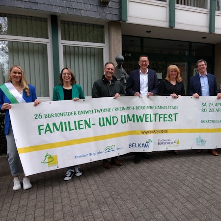 Svenja Mühlsiegl, Andrea Lunau, Manfred Habrunner, Dirk Runge, Monika Lichtinghagen-Wirths, Stephan Santelmann, Daniela Zyball und Christian Meuthen präsentieren das Transparent für die 26. Burscheider Umweltwoche.