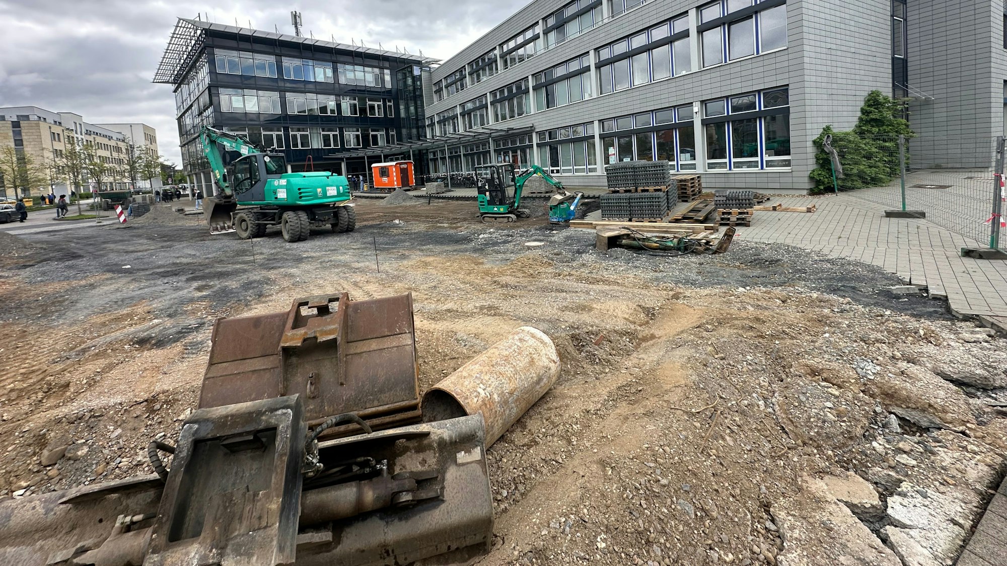 Bagger stehen auf Baustelle vor dem Haupteingang der Hochschule.