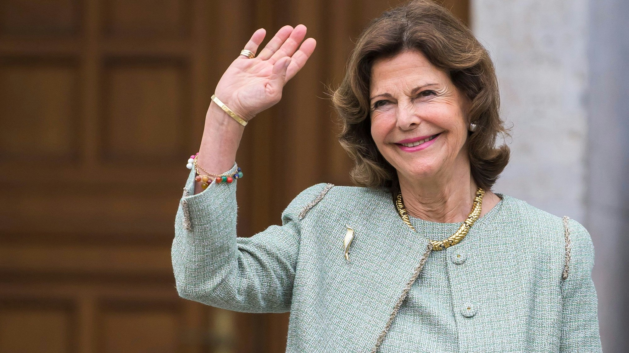 Königin Silvia winkt bei einem Festakt in Heidelberg.