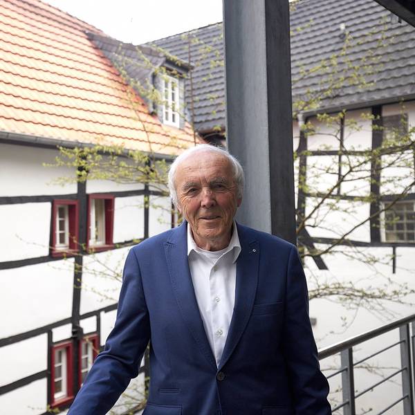 Das Bild zeigt Frank Günter Zehnder. Im Hintergrund sind Fachwerkhäuser zu sehen.