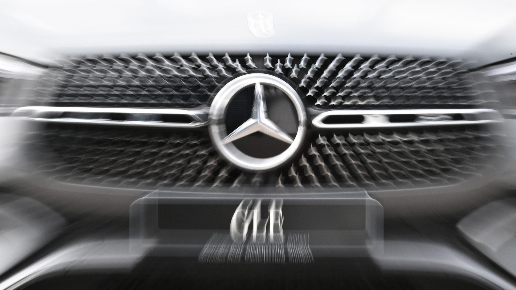 Das Logo der Automarke Mercedes-Benz ist an der Front eines Fahrzeugs angebracht.