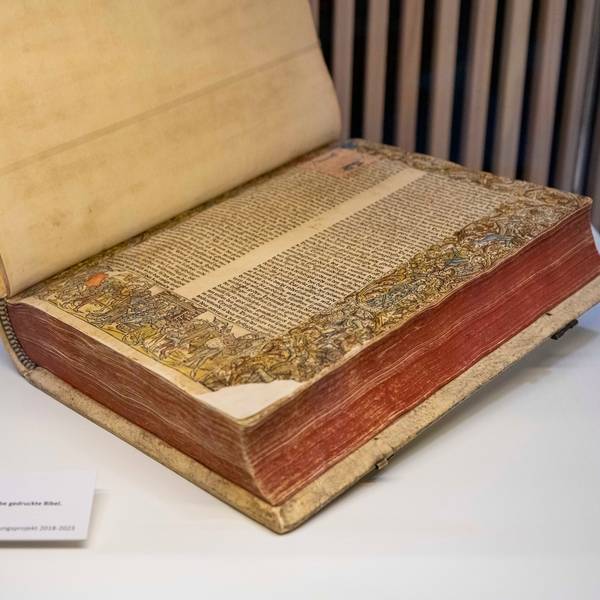 Auf dem Bild ist das große Buch zu sehen, die Seiten sind üppig bemalt.