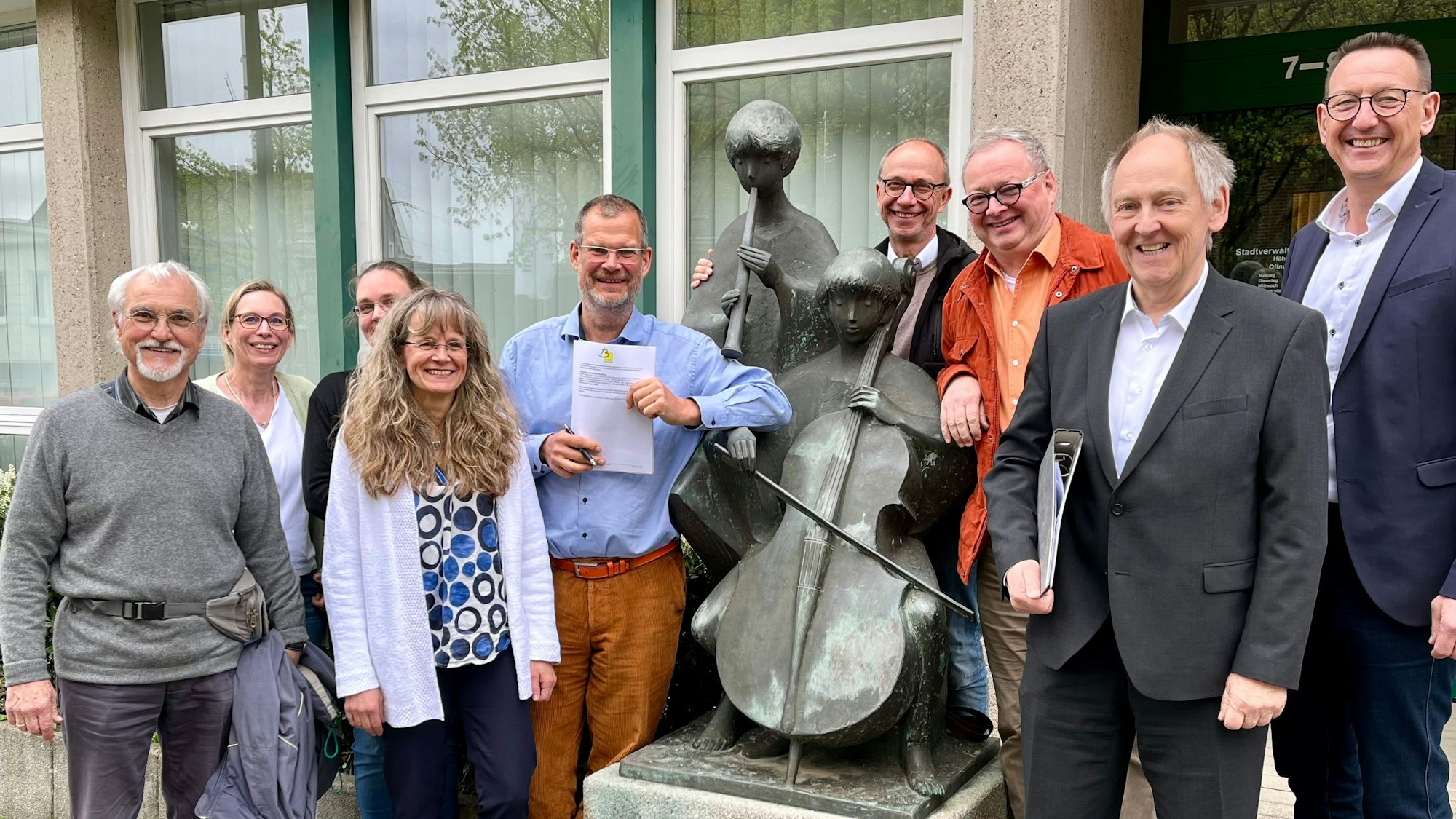 Tillmann Werner, Claudia Schroen, Stephanie Kernke, Ulrike Detering, Klaus Perthel, Martin Mudlaff, Ulrich Haas, Axel Plutte und Dirk Runge (von links) stehen für die neue Musik- und Orchesterschule vor dem Burscheider Rathaus.