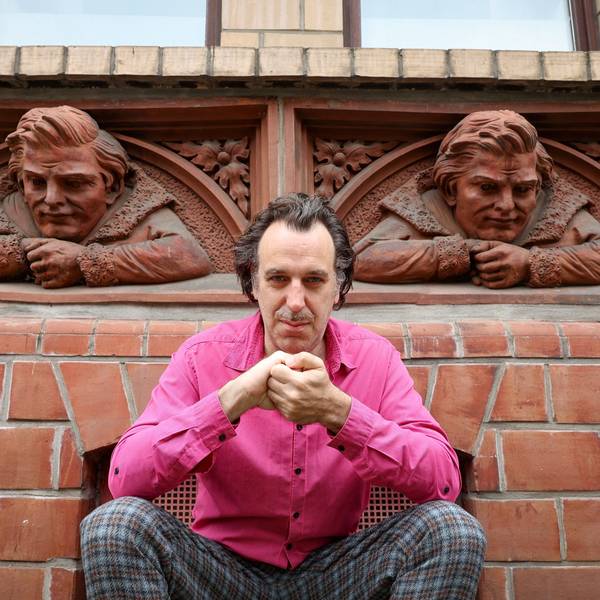 Der Musiker Chilly Gonzales kniet vor einem Haus in der Richard-Wagner-Straße, dessen Fassaden Relief-Büsten von Richard Wagner zieren.