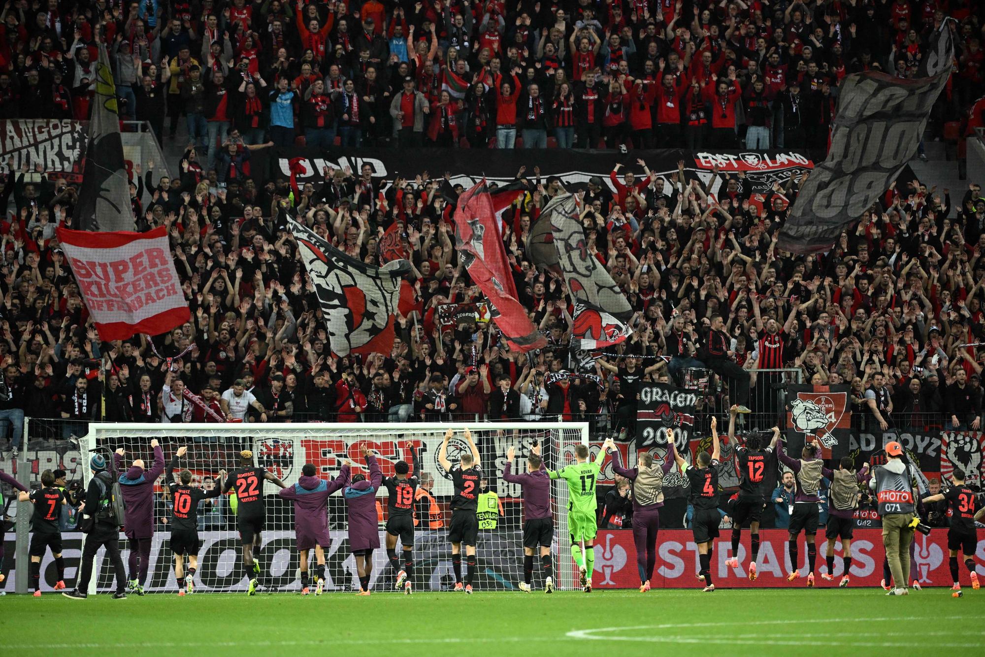 Bayer Leverkusen's players celebrate with fans at the end of the UEFA Europa League quarter-final first leg football match between Bayer 04 Leverkusen and West Ham United FC in Leverkusen, western Germany on April 11, 2024. Bayer Leverkusen won the match 2-0. (Photo by INA FASSBENDER / AFP)