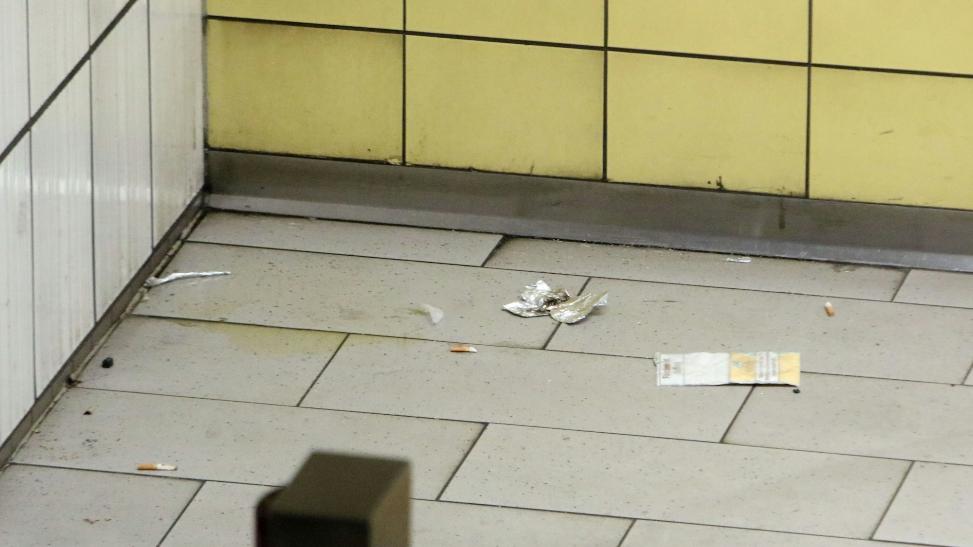 Auf dem gekachelten Boden der U-Bahn-Haltestelle Friesenplatz liegt Alufolie.