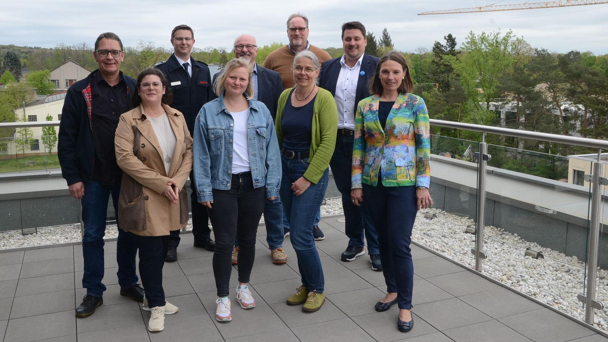 Eine Gruppe von Männern und Frauen auf dem Dach eines Verwaltungsgebäudes.
