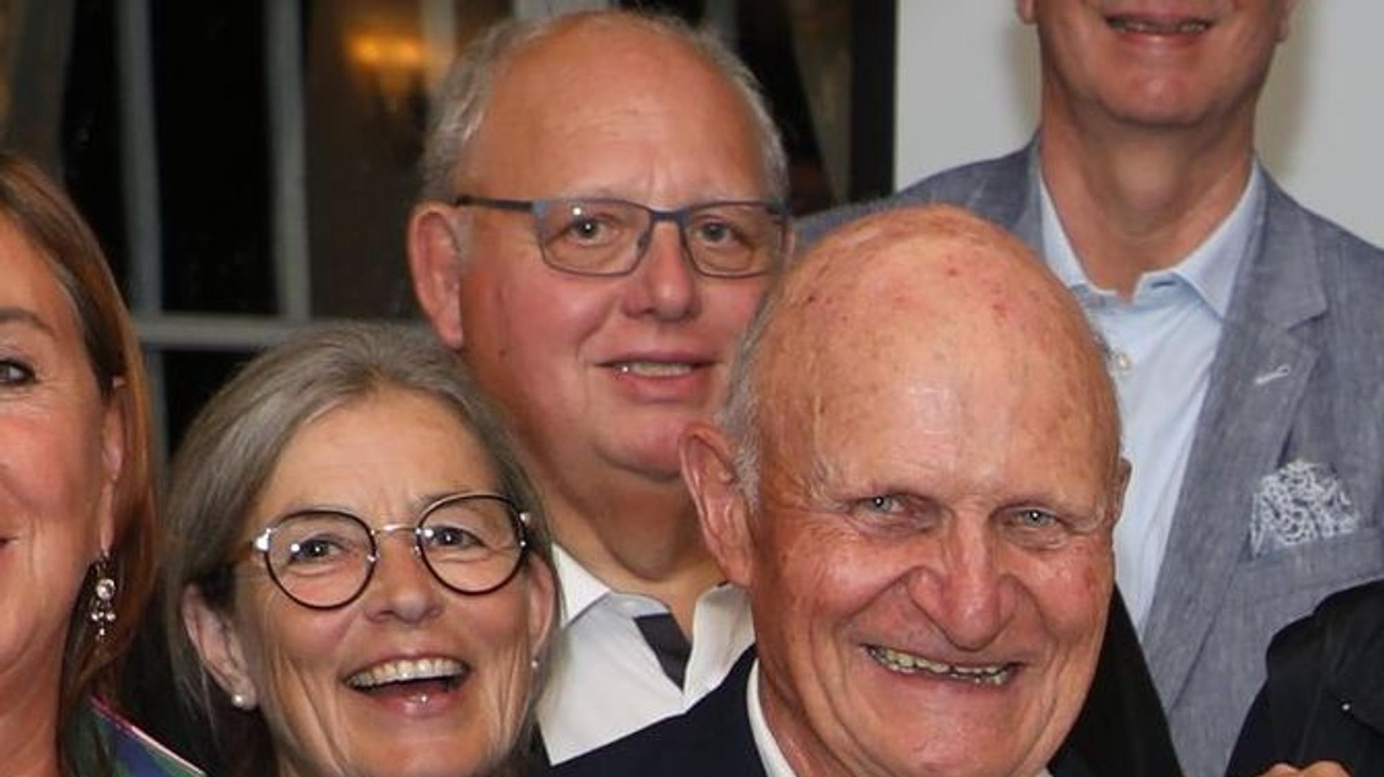 Menschen in Schloss Auel stehen in einer Gruppe und lächeln in die Kamera.