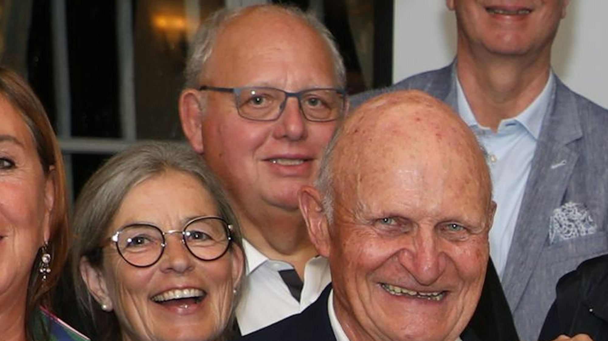 Menschen in Schloss Auel stehen in einer Gruppe und lächeln in die Kamera.