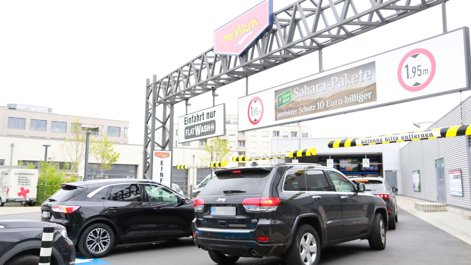 Schlangen vor der „Mr. Wash“-Waschanlage, die mit einem Sahara-Paket wirbt.