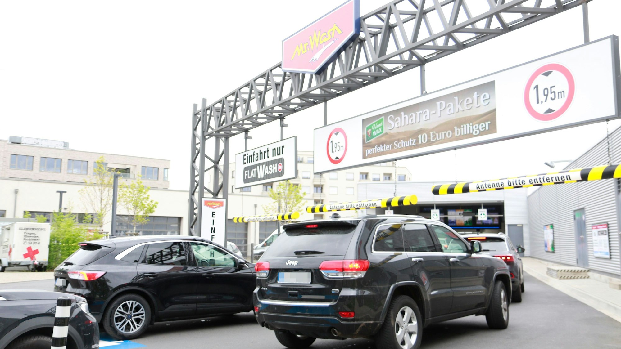 Schlangen vor der „Mr. Wash“-Waschanlage, die mit einem Sahara-Paket wirbt.