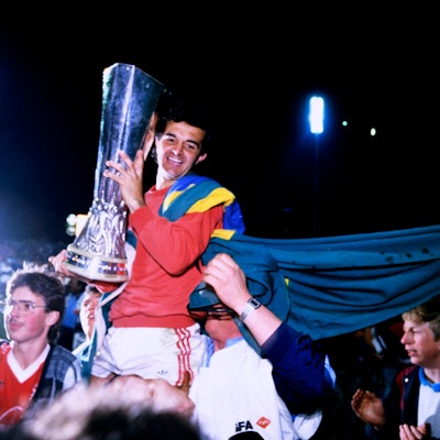 Ein Spieler von Bayer Leverkusen wird mit dem UEFA-Pokal in den Händen von den Fans in die Höhe gehoben.