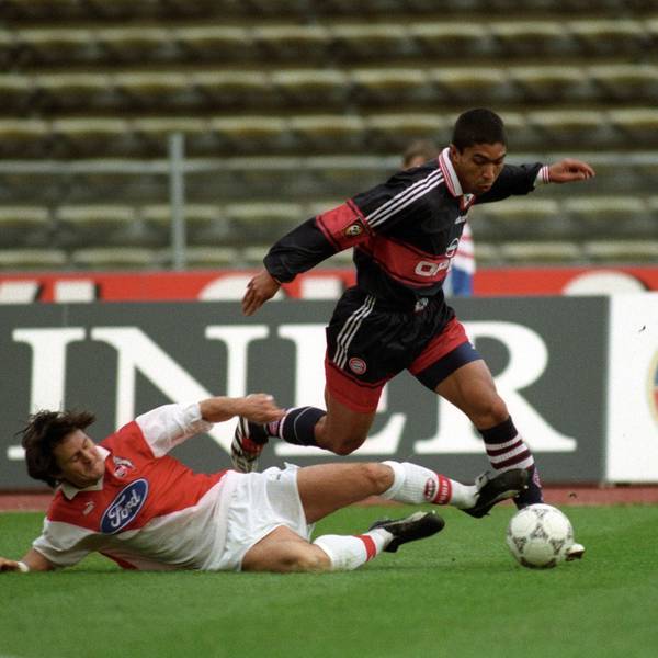 Ein Fußballspieler grätscht seinem Gegenspieler den Ball weg.