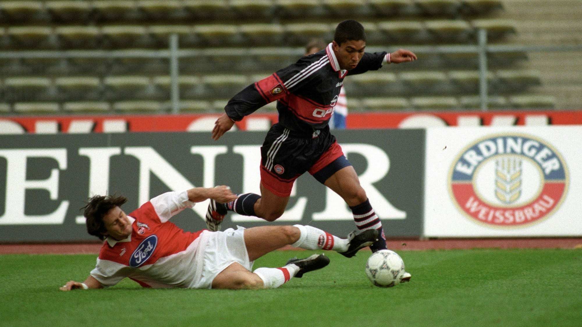 Ein Fußballspieler grätscht seinem Gegenspieler den Ball weg.