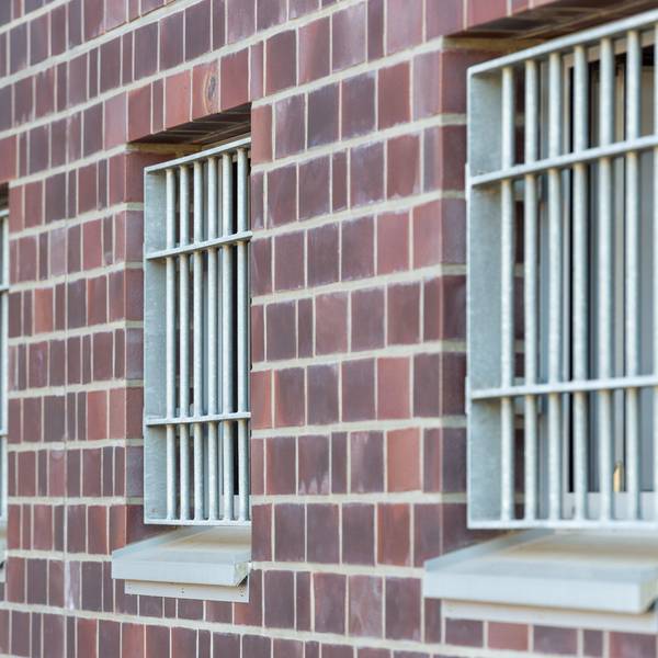 Die Fenster einer Justizvollzugsanstalt sind vergittert.