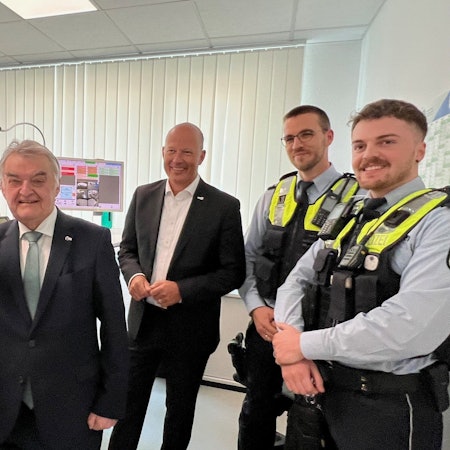 Das Bild zeigt NRW-Innenminister Herbert Reul und Landrat Frank Rock sowie zwei Polizeibeamte in der neuen Wache in Lechenich.