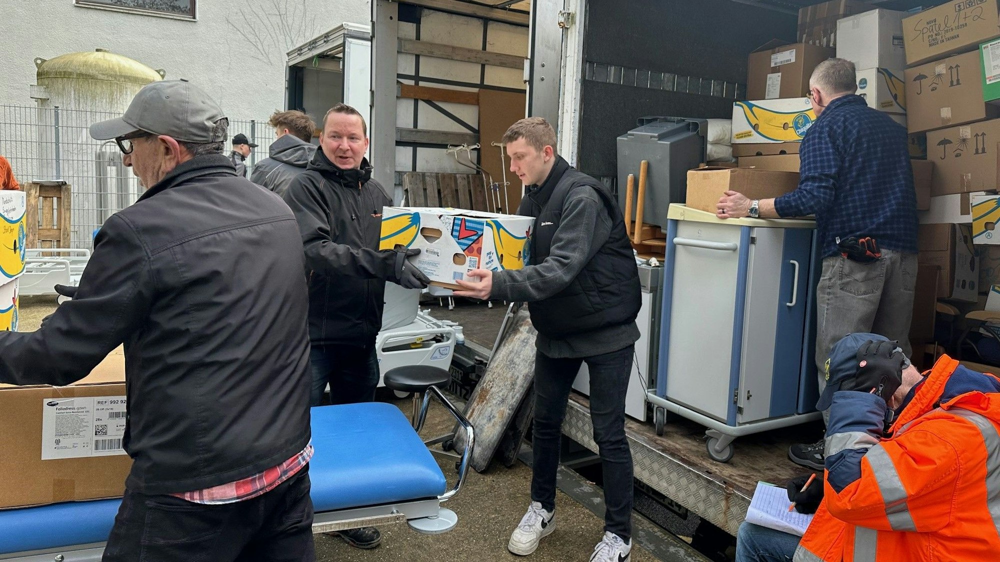 Helfer der Humanitären Hilfe Overath und Bergisch Gladbach verladen für einen Hilfskonvoi ins westukrainische Lviv Kartons, Krankenhausbetten und weiteres medizinisches Material.