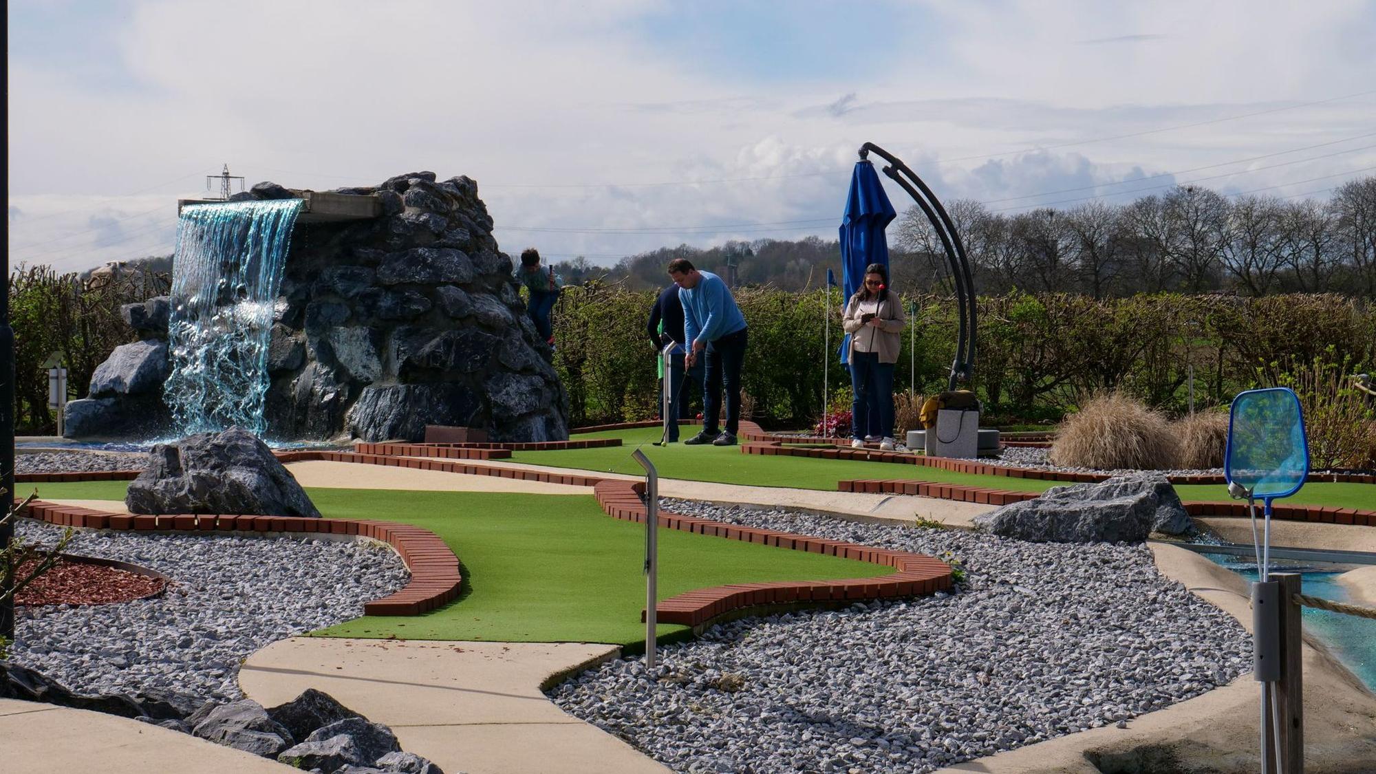 Das Bild zeigt eine moderne Minigolf-Anlage mit Kunstrasen.