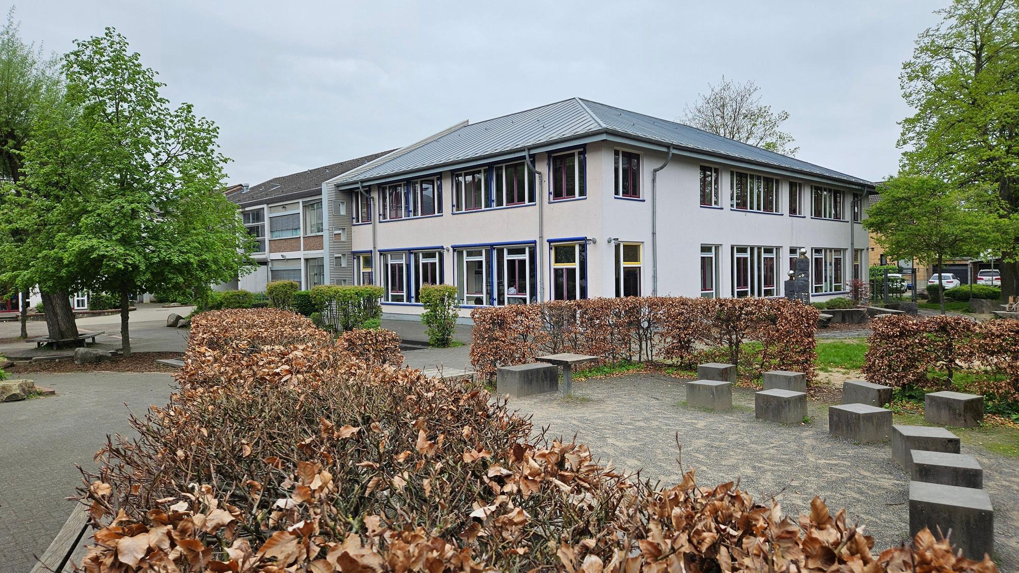 Im Bild die Gesamtschule, davor ein leerer Schulhof.