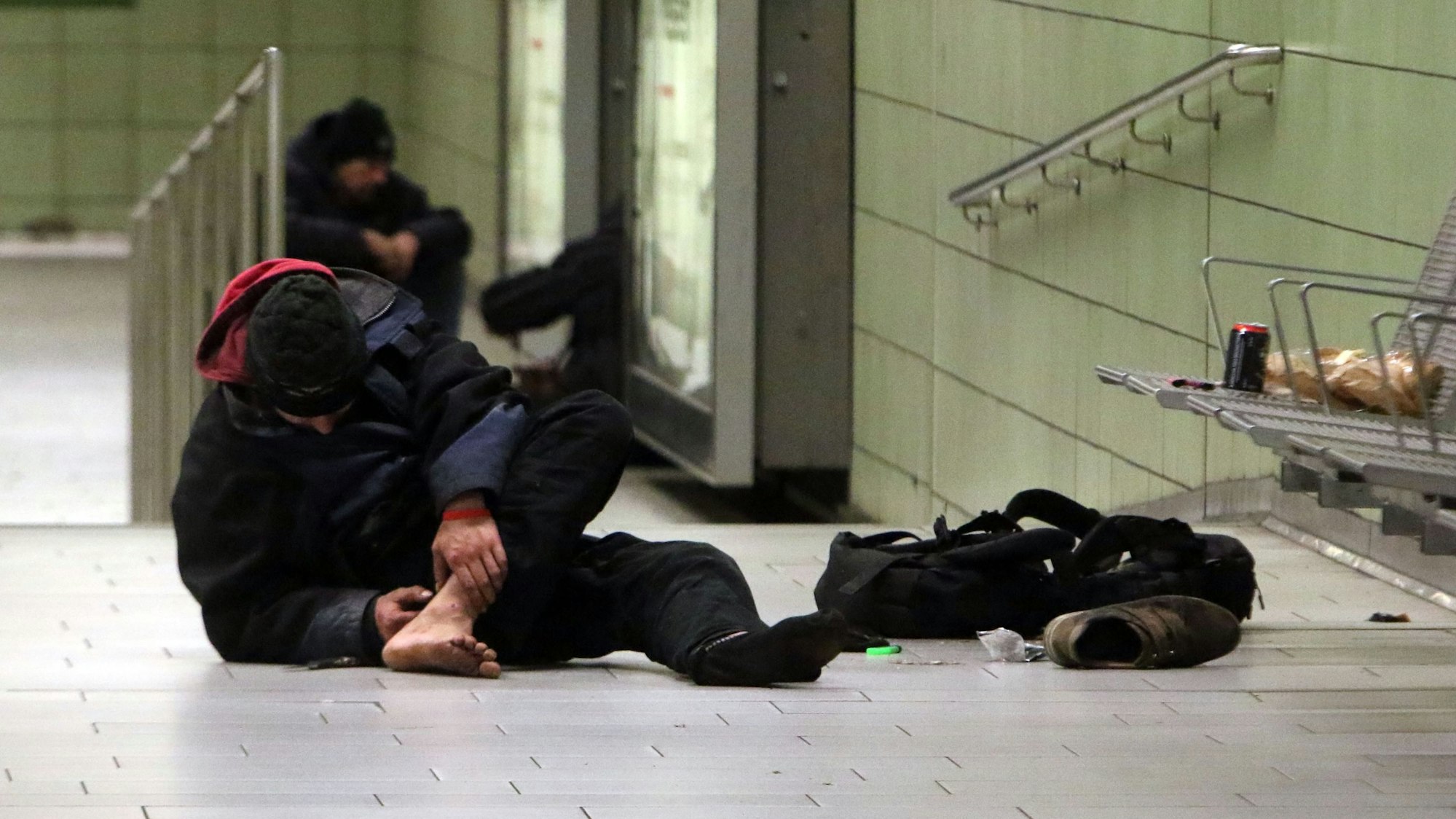 An der U-Bahnhaltestelle Friesenplatz setzt sich ein Drogenkonsument eine Spritze in seinen Fuß.
