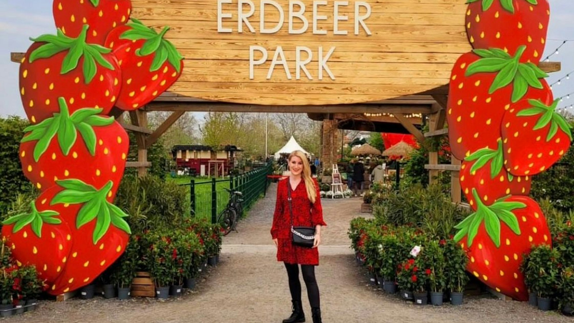 Auf dem Foto ist eine Besucherin vor einem Bogen aus überdimensionalen Erdbeeren zu sehen.
