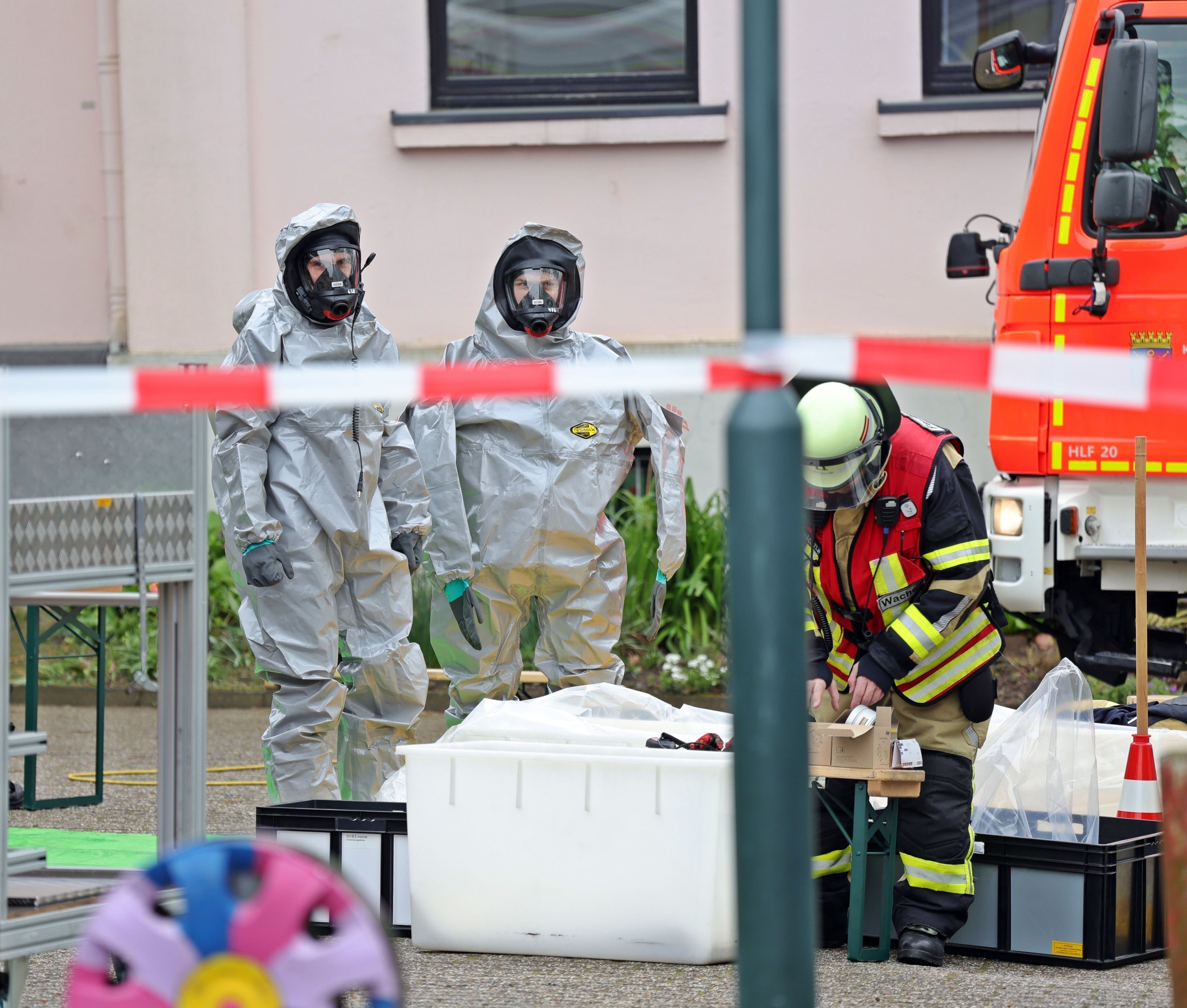 12.04.2024, Nordrhein-Westfalen, Solingen: Kräfte der Feuerwehr sind zum Teil in speziellen Schutzanzügen bei einem Austritt von Chlorlauge in der Schwimmhalle einer Schule im Einsatz. Ein technischer Defekt an einer Pumpe soll nach ersten Erkenntnissen dazu geführt haben. Der Unterricht wurde am Morgen beendet. (zu dpa/lnw «Chlorlauge in Schwimmhalle ausgetreten») Foto: Gianni Gattus/dpa +++ dpa-Bildfunk +++