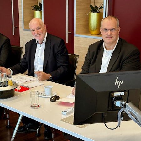 Der Vorstand mit dem Vorsitzenden Frank Grebe, Dirk Steinbach und Mario Scheidt sitzt an einem langen Tisch.